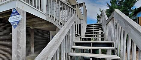 A wooden staircase leading to a building with a closed garage door.