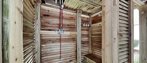 Une structure en bois dotée d’un toit à lattes et d’un élément central en métal.
