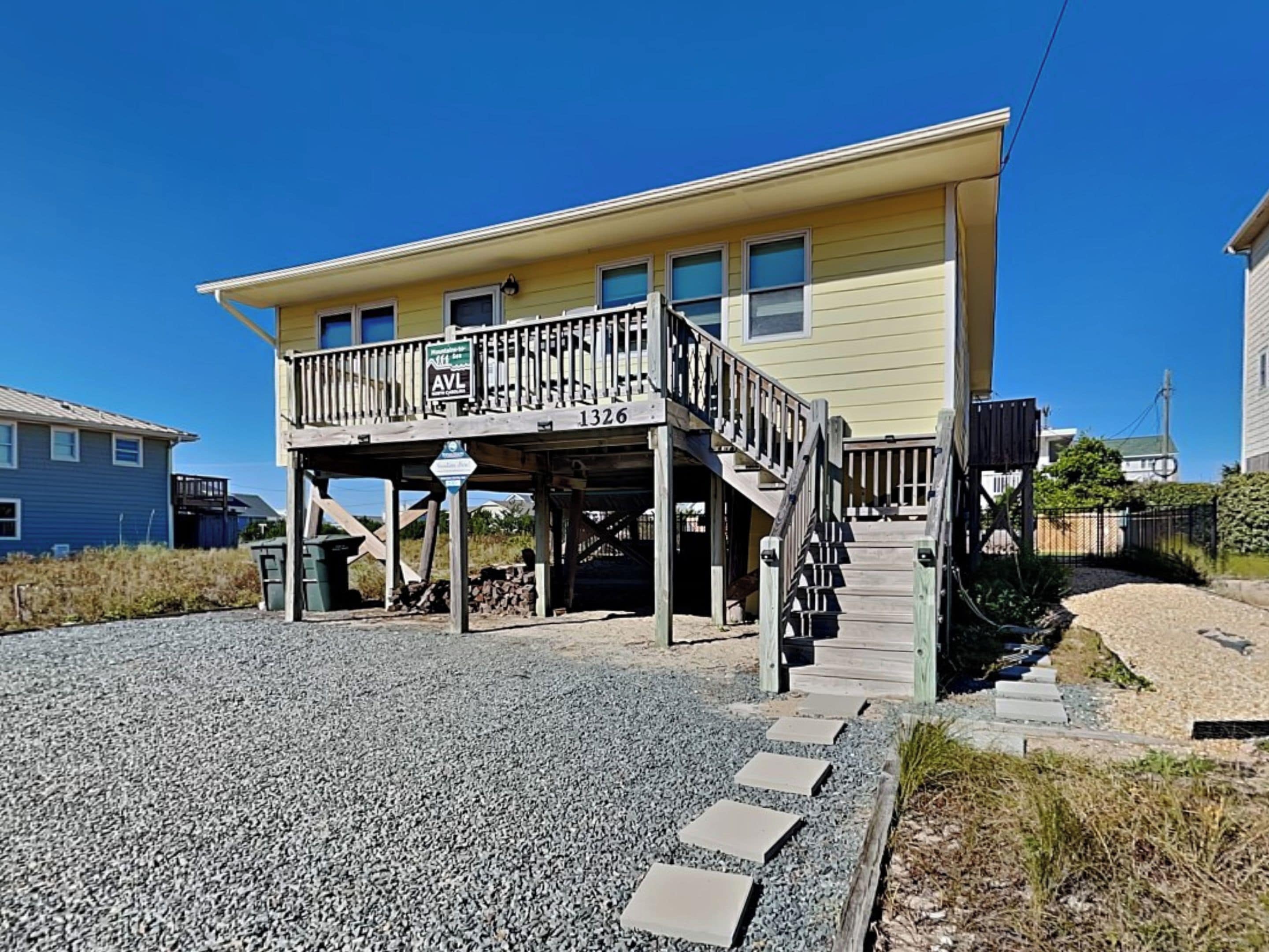 A two-story house with a balcony and a covered porch area.