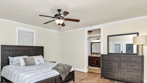 A bedroom with a bed, dresser, and ceiling fan. - Comfy West Columbia Get-Away (West Columbia)