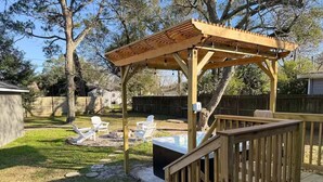 A wooden deck with a pergola, outdoor seating, and a hot tub. - Coastal Getaway w/HotTub in La Marque! (La Marque)