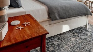 A tented room with a bed, a table with starfish, and a view of the water. - Luxury Coastal Dome - Private Hot Tub, Oceanfront Deck, Firepit & Parking (LaHave)
