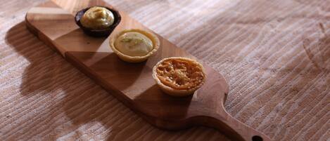 A wooden board with three pastries on a textured fabric surface.