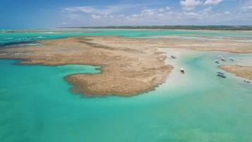 Na praia, guarda-sóis, toalhas de praia, massagens na praia