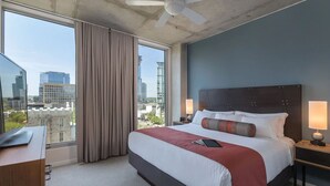 A hotel room with a large bed, a desk, and a view of the cityscape. - Lovely Austin Resort Perfect for the whole family! (Austin)