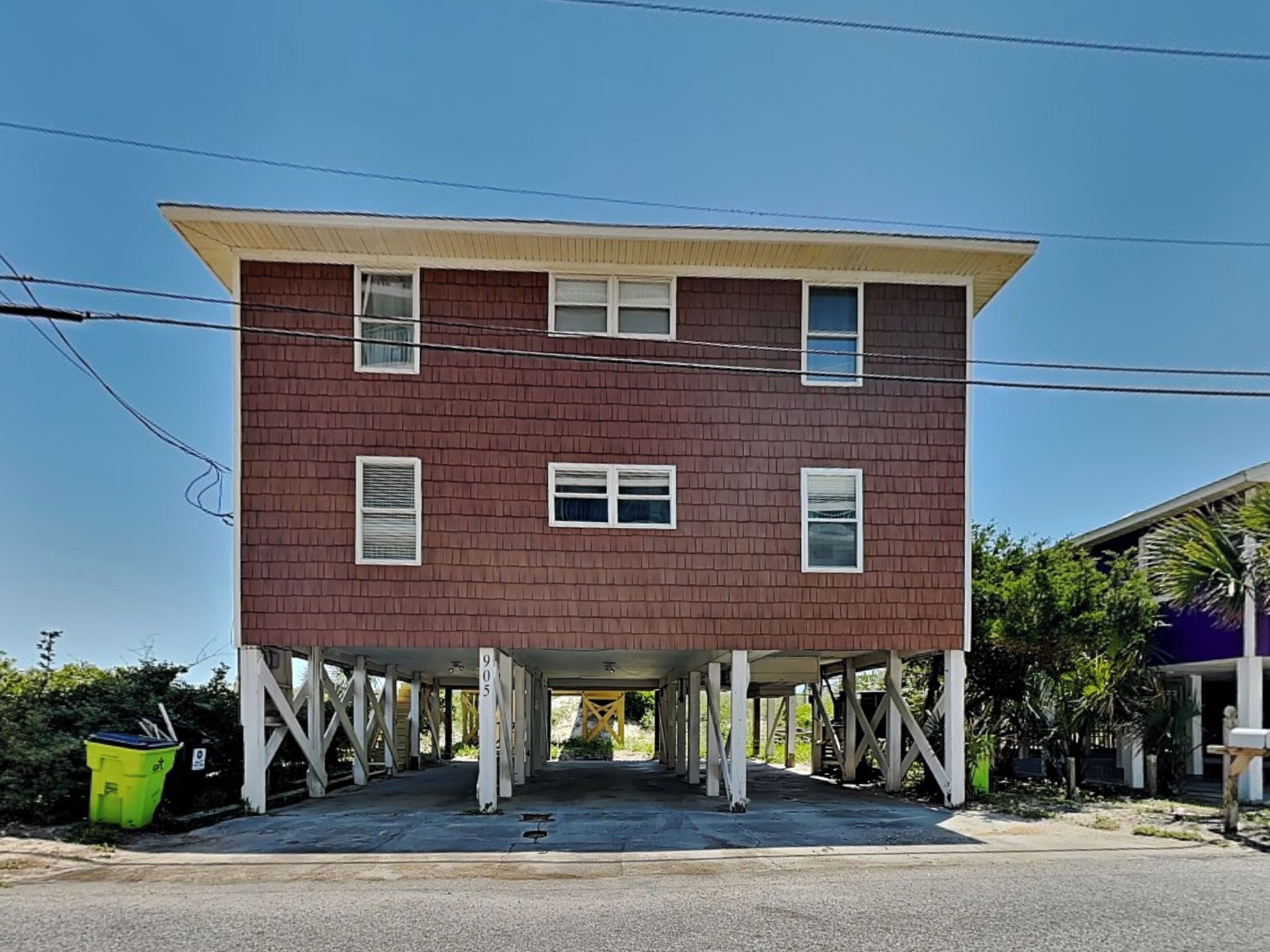 A two-story building with a flat roof and a covered entrance area.