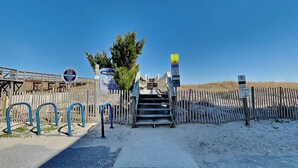 A beach entrance with a wooden fence, a staircase, and a parking sign. - The Sweet Spot by Carolina Retreats (Carolina Beach)