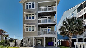 A multi-story building with a flat roof, multiple balconies, and a covered entrance area. - The Sweet Spot by Carolina Retreats (Carolina Beach)