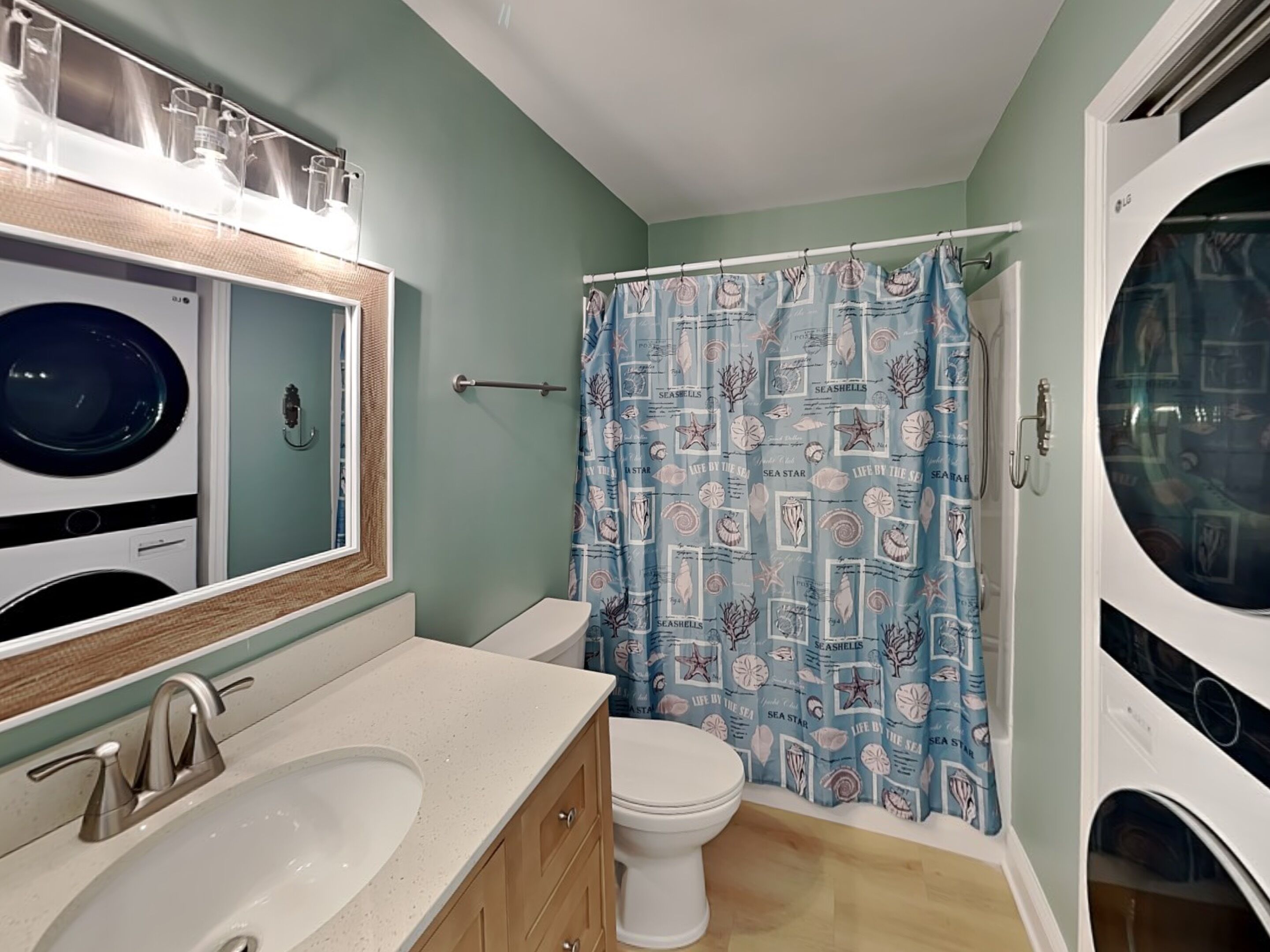 Un baño con inodoro, lavamanos y dos lavadoras.