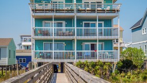A multi-story building with balconies, a wooden deck, and a view of the beach. - The Sandcastle @ Tiki by Carolina Retreats (Carolina Beach)