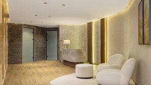 A modern lobby with a curved wall, a reception desk, a seating area with two chairs, and a wooden floor. - Le Méridien Casablanca (Casablanca)