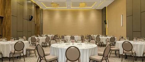A conference room with round tables, chairs, and a polished floor.