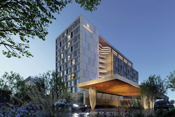 A modern hotel with a prominent 'R' logo, a large glass facade, and a unique wooden overhang. - Renaissance Korla Hotel (Korla)