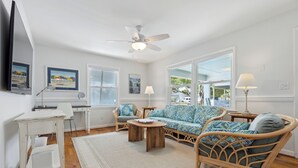 A living room with a sofa, chairs, a coffee table, and a ceiling fan. - Rec Player's Retreat by Carolina Retreats (Carolina Beach)