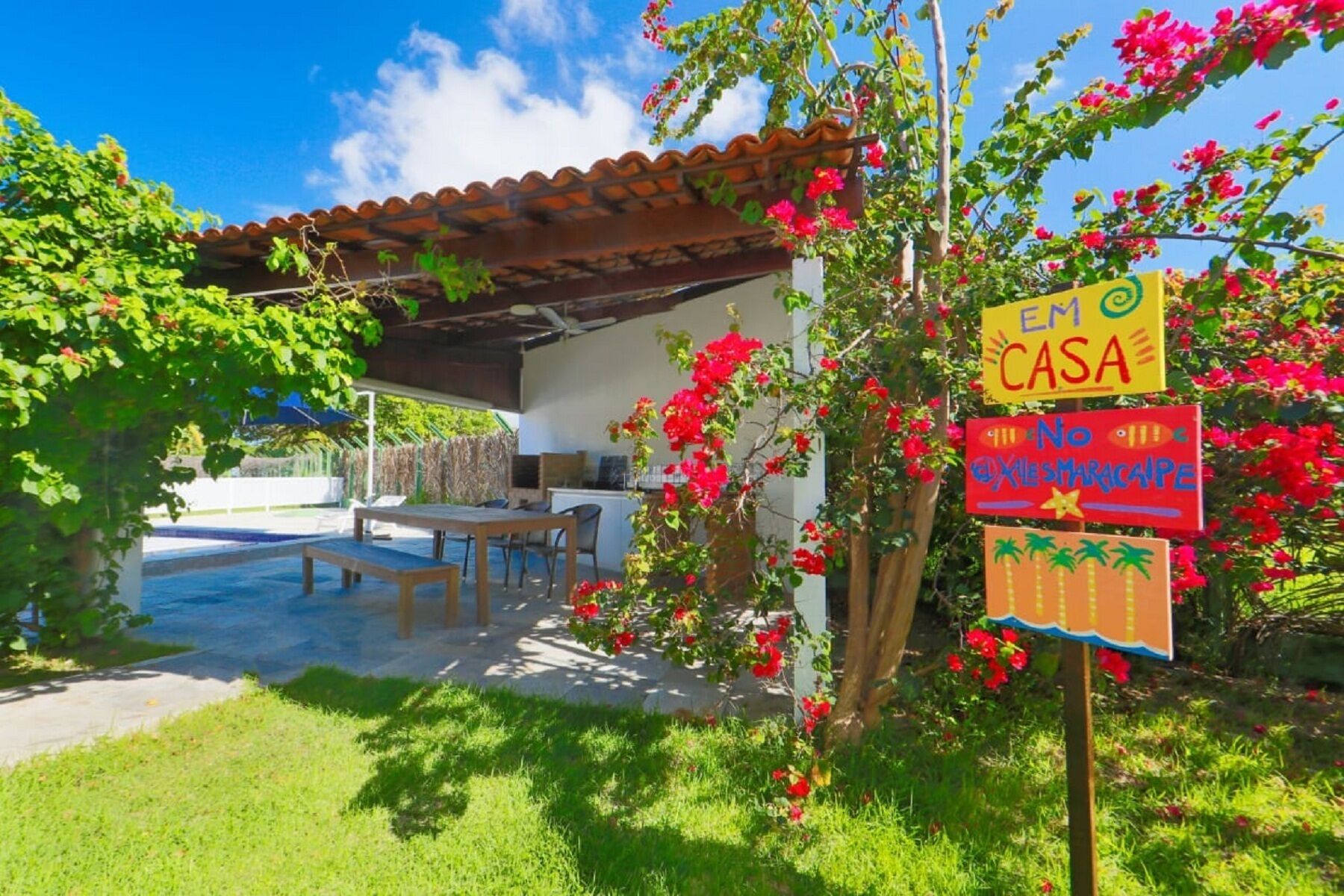 A house with a patio, outdoor furniture, and colorful signs.