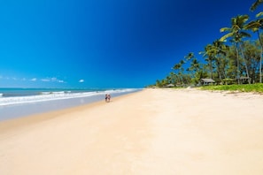Na praia, areia branca, toalhas de praia