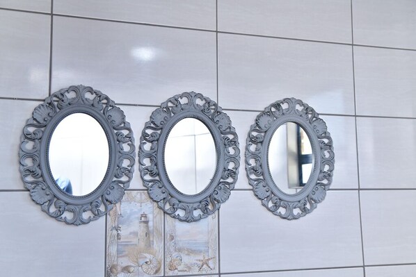 Three ornate mirrors with intricate designs on a tiled wall.