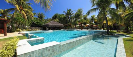 Een buitenzwembad, parasols bij het zwembad en ligstoelen