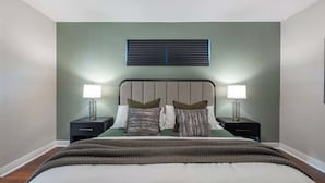 A bedroom with a bed, two bedside tables, a ceiling fan, and a window with blinds. - Modern Luxury 5BR Pool Movie-Game Rm @Encore 7770 (Kissimmee)