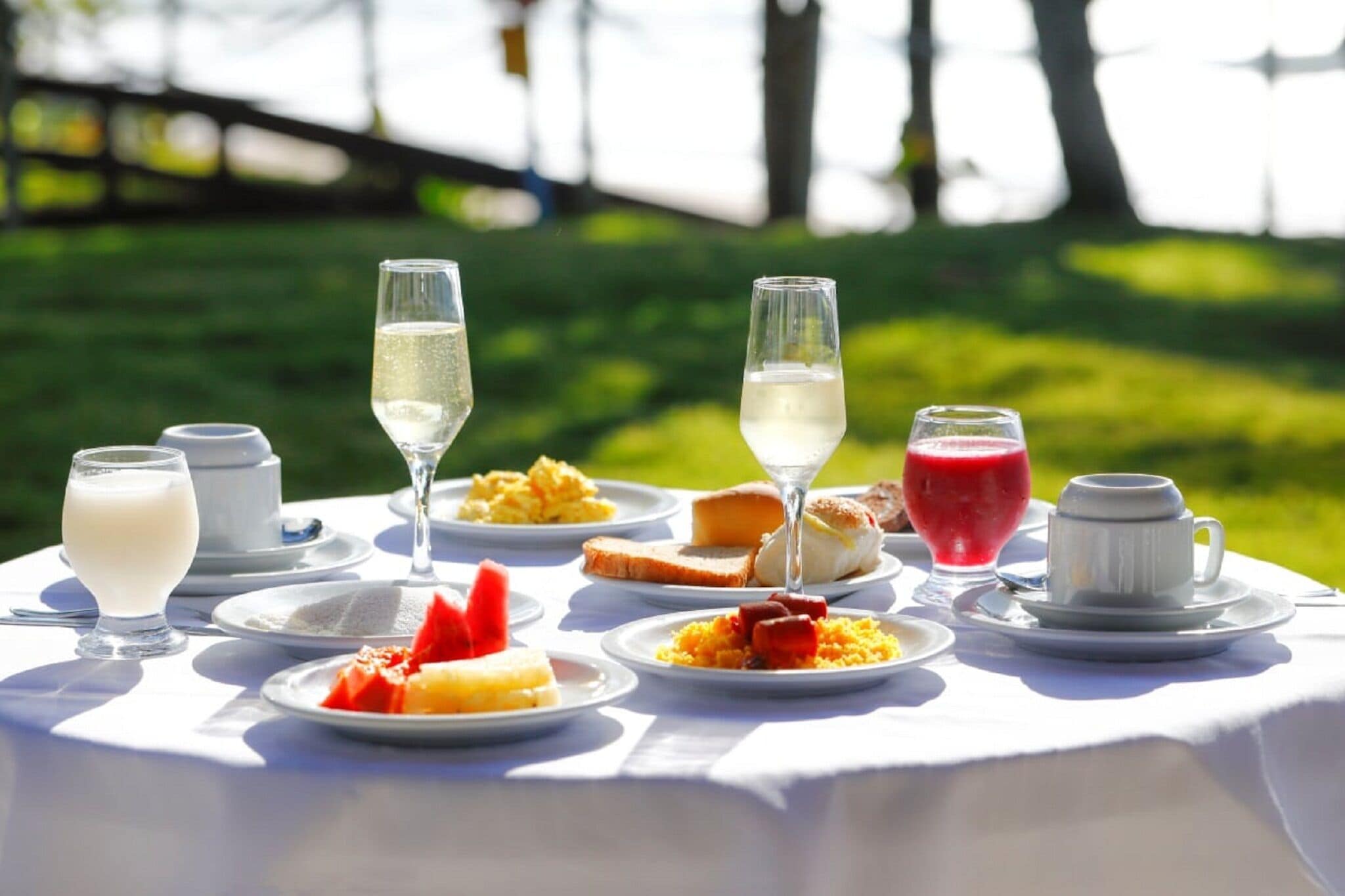 A table set outdoors with various dishes and drinks.