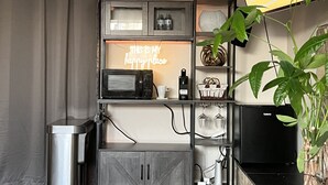 A modern living room with a grey cabinet, a neon sign, and a TV on the wall.