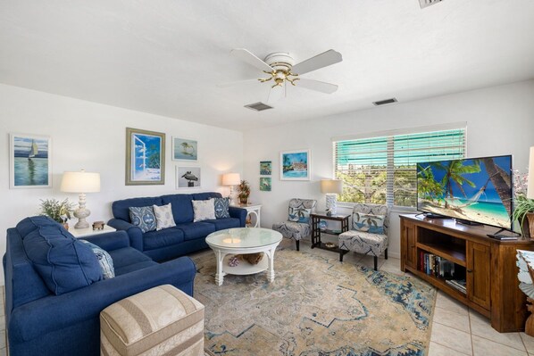A living room with a blue sofa, a coffee table, and a TV on a wooden cabinet.