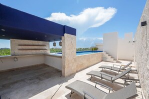 An outdoor patio with a pool, lounge chairs, and a covered barbecue area. - Lux 2BR Penthouse w/Private Plunge Pool/Aldea Zama (Tulum)