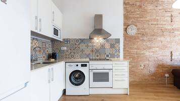 Cocina compacta con lavadora, horno y microondas.