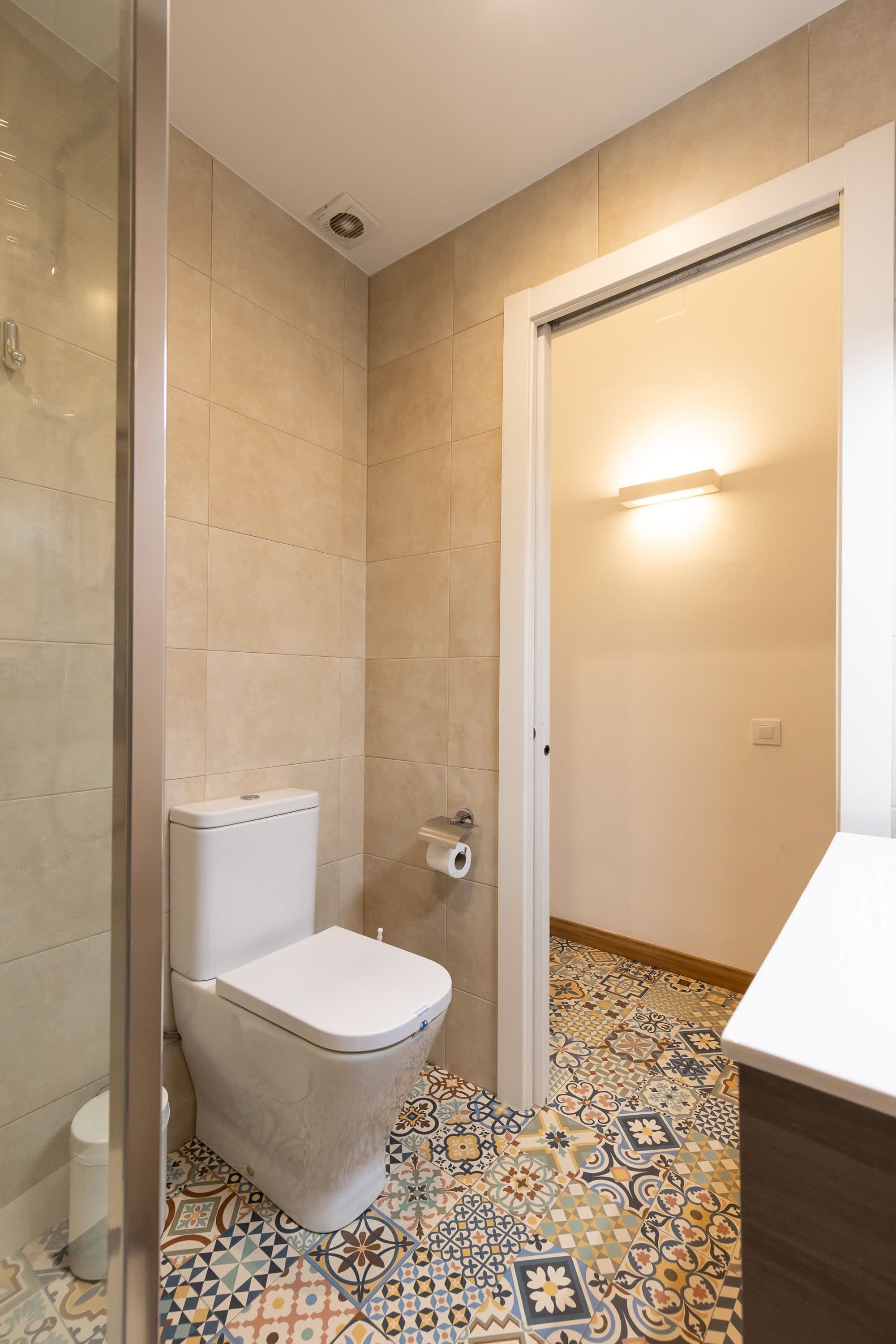A bathroom with a toilet, a shower, and a sink.