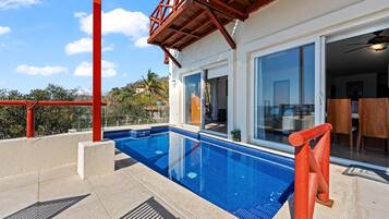 A modern house with a swimming pool, large windows, and a patio area.