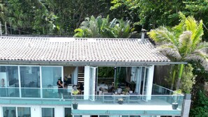 A modern multi-story house with a glass balcony, a swimming pool, and lush greenery. -  Luxury Ocean Front Loft in Rio De Janeiro Joa (Joá Rio de Janeiro)