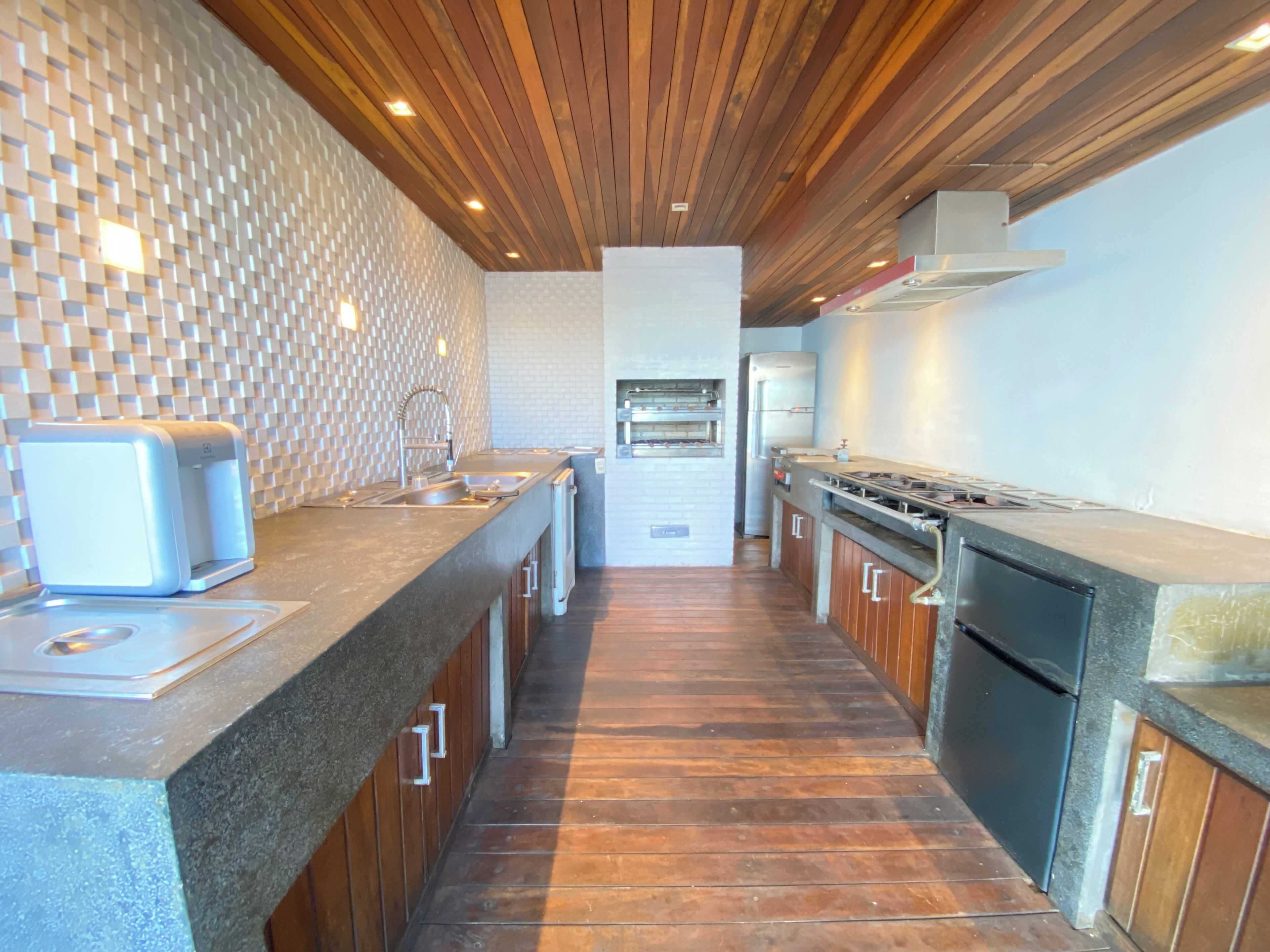 A modern kitchen with wooden cabinets, a granite countertop, and a built-in oven.