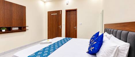 Un dormitorio moderno con una cama, un ventilador de techo y puertas de madera.