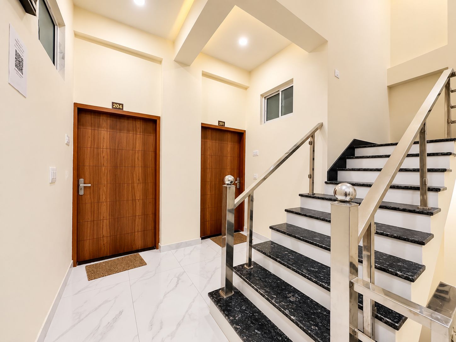A modern interior with a marble staircase, wooden doors, and a minimalist design.