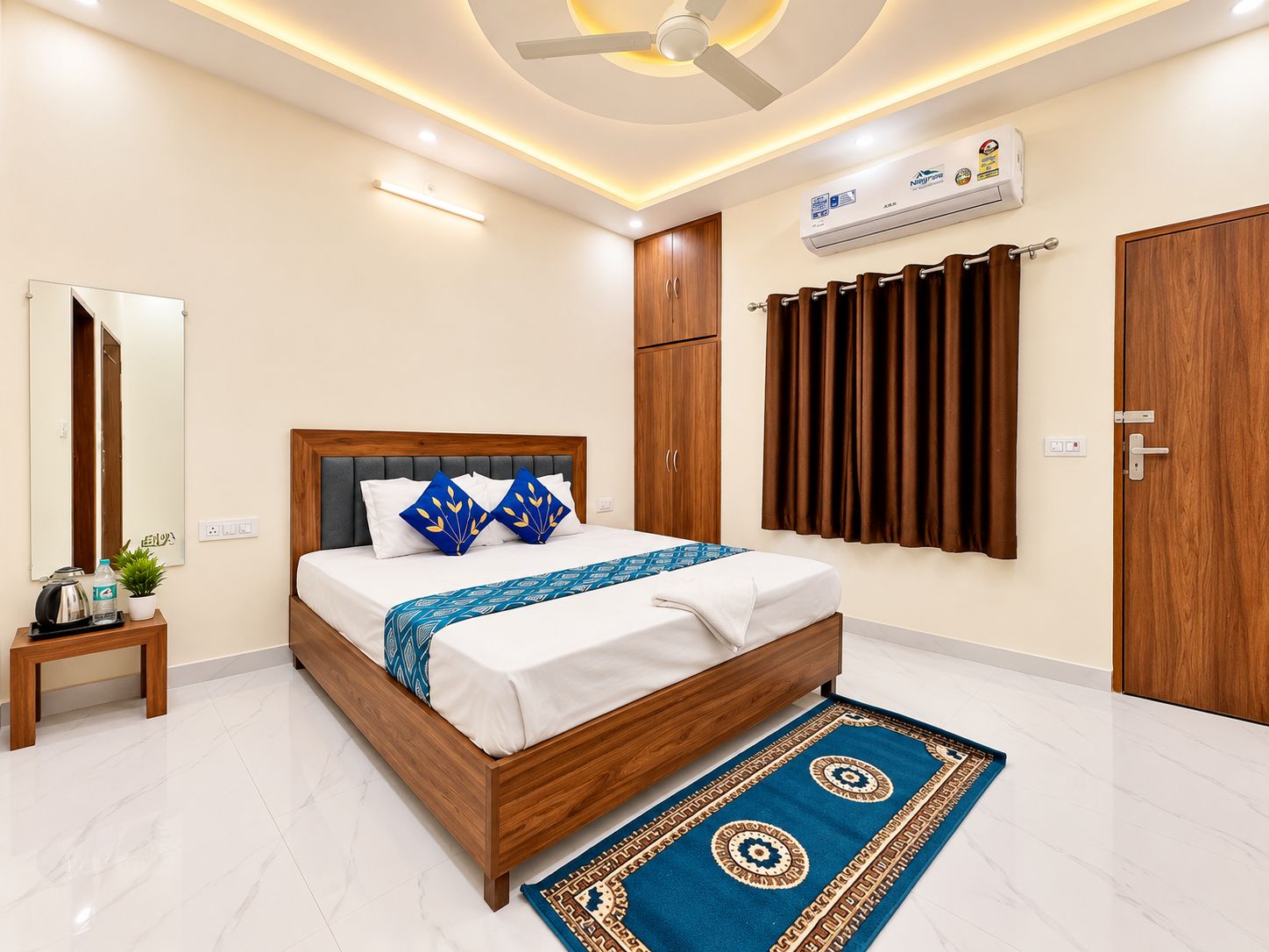 A modern bedroom with a wooden bed, a ceiling fan, an air conditioning unit, and a patterned rug.