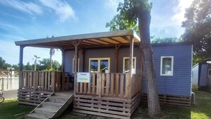 Un petit bâtiment d’un seul étage, doté d’une terrasse en bois et d’un porche couvert.