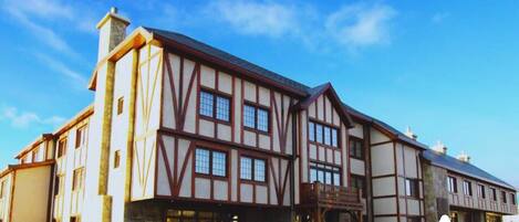 A large, multi-story building with a traditional architectural style, featuring exposed wooden beams and large windows.