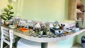 Una cocina con salpicadero a cuadros, una estufa y diversos utensilios de cocina sobre la encimera.