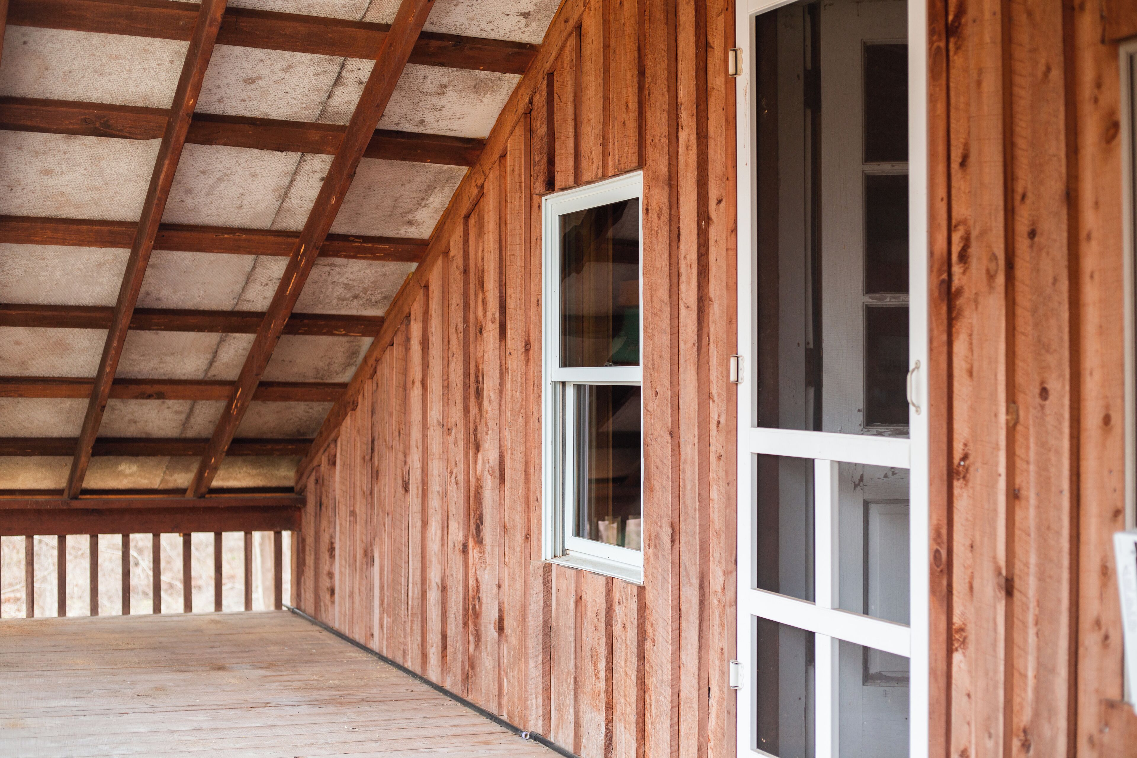 A wooden interior with a sloped ceiling and a large window.