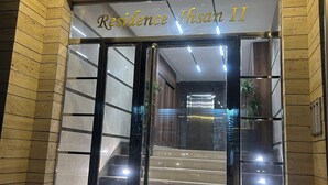 A hotel entrance with a sign reading "Résidence Ishan II," featuring a glass door, a staircase, and a security camera. - Charming studio Urban cozy studio (Casablanca)
