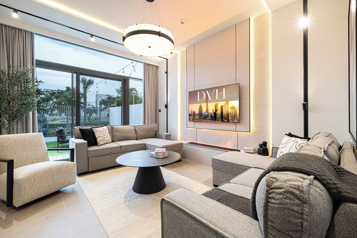 Un salon moderne comprenant un ensemble de canapés, une table basse et une grande fenêtre donnant sur l’extérieur.