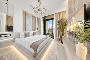 A modern bedroom with a large bed, a chandelier, a TV, and a balcony with curtains. - Arabian Ranches 3 Luxury 4 Bedroom Villa (Dubai)