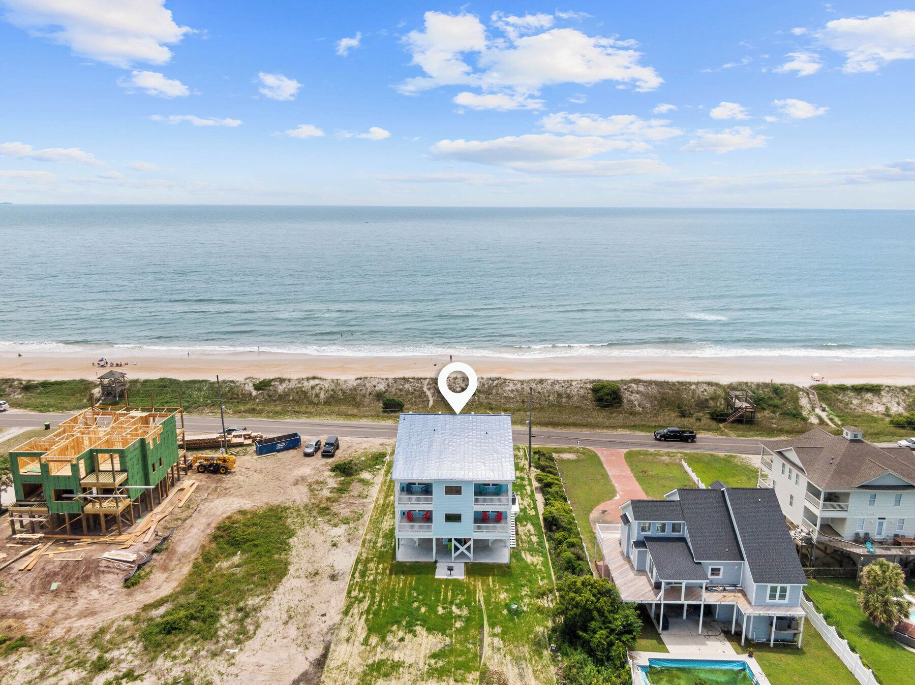 A coastal property with a large house, a smaller building, and a construction site.