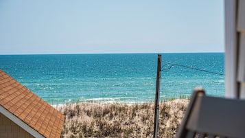 A beach view with a wooden structure and a utility pole.