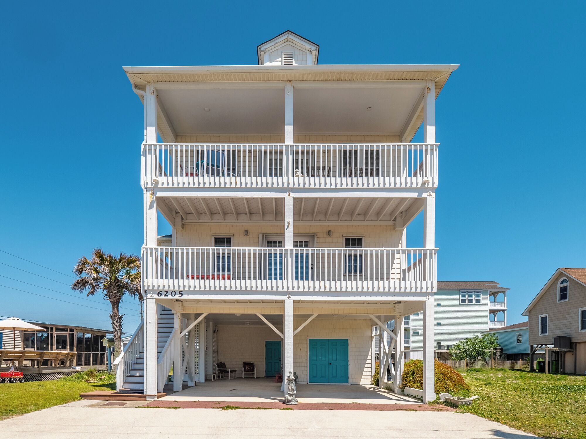 A multi-story building with a covered front porch and a blue door.