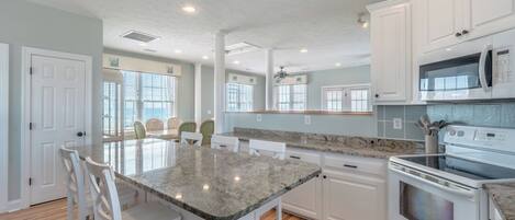 A kitchen with white cabinets, a granite countertop, and a built-in oven.