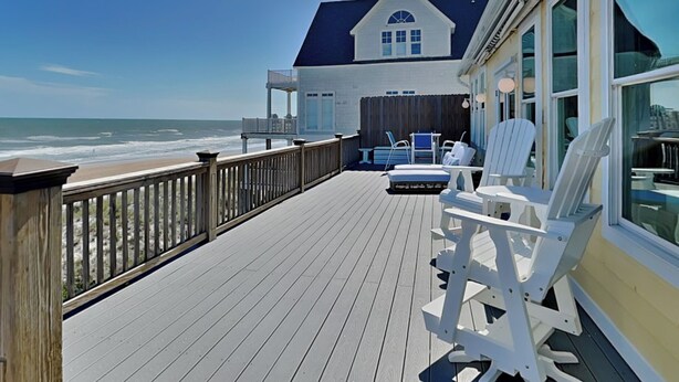 A wooden deck with white Adirondack chairs, a pool table, and a view of the ocean. - Sunny Side Up by Topsail Realty (Sneads Ferry)