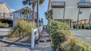 A pathway leading to a private property with a 'PRIVATE PROPERTY' sign, surrounded by vegetation and a building with balconies. - Sassy Seahorse by Topsail Realty (Holly Ridge)