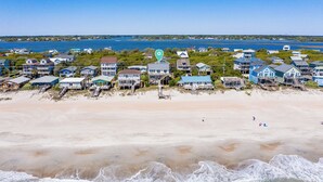 A coastal residential area with houses along the beach, a clear view of the ocean, and a calm beach scene. - You're The Tops by Topsail Realty (Holly Ridge)