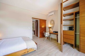 A bedroom with a bed, a desk, a chair, and a wardrobe.
